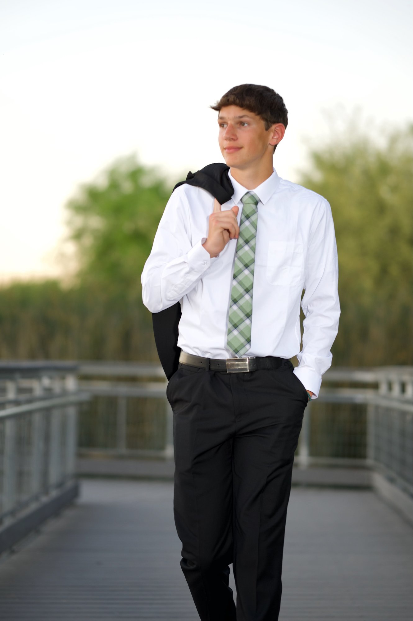 Senior boy in suit on Riparian Preserve boardwalk
